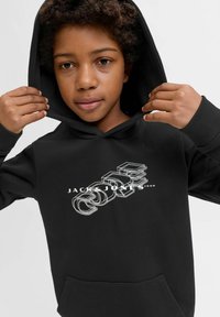 Felpa nera con tasca frontale, con un logo in testo bianco contornato. Materiale morbido, vestibilità casual con cappuccio regolabile.