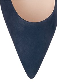 Bout pointu d'une chaussure à talon haut en daim bleu marine avec un bord intérieur arrondi et une semelle intérieure beige.