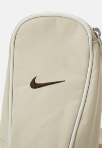 Nike Sportswear ESSENTIALS CROSSBODY UNISEX - Rankinė per petį - sanddrift/sail/baroque brown