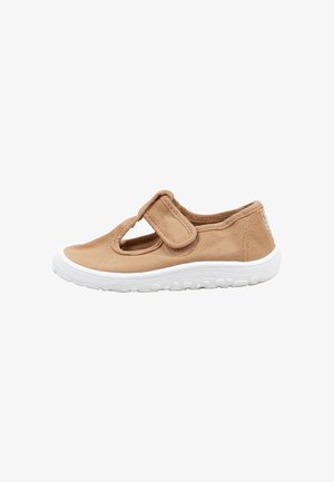 Lichtbruine canvas schoen met witte rubberen zool en verstelbare klittenbandsluiting, ontworpen voor comfort en gemakkelijk dragen.