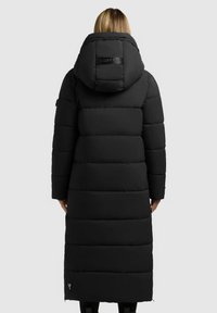 Giacca a vento nera con un design lungo e dritto. Presenta un cappuccio, una texture trapuntata e una patch con logo sulla schiena. Dettaglio con zip all'orlo.