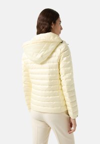 Padded jacket in light yellow with a hood, featuring horizontal quilting, a zip closure, and a fitted silhouette. Smooth, shiny texture.
