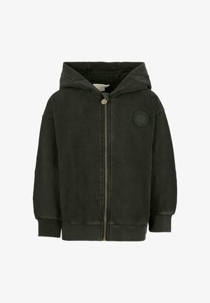 Hoodie vert foncé en tissu doux, avec une fermeture éclair, des poignets élastiques et un patch logo rond sur la poitrine.