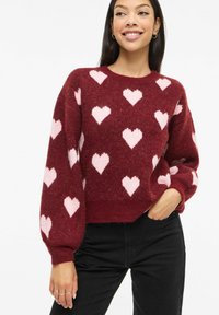 Bordo džemper sa uzorcima ružičastih srca, teksturirani pletivo, okrugli izrez i naborani rukavi. Skraćeni dizajn.