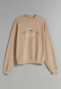 Felpa beige con collo a giro e maniche raglan. La parte anteriore presenta un testo bianco e marrone: "BABE YOU ARE MY SOUL MATE SINCE 2001." Texture morbida.