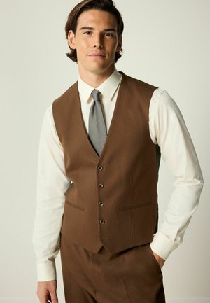 Brown wool vest with five buttons, notched lapels, and front pockets, paired with a white shirt and a patterned tie. No visible textures.