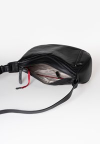 Borsa a tracolla nera in pelle con finitura testurizzata, chiusura con zip, interno rosso e tracolla regolabile. Foderata in tessuto morbido.