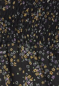 Tecido preto com uma textura franzida, adornado com pequenos padrões florais em amarelo, roxo e branco. Apresenta um material suave e leve.