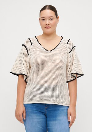 Weißes Netzoberteil mit schwarzen gewellten Kanten, weiten Glockenärmeln und V-Ausschnitt, das über intricate offene Strickdetails verfügt.
