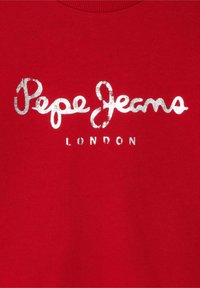 Punane dressipluus, millel on hõbedastes metallilistes tähtedes "Pepe Jeans LONDON". Pehme tekstuur ja ribaga ümar kaelus.