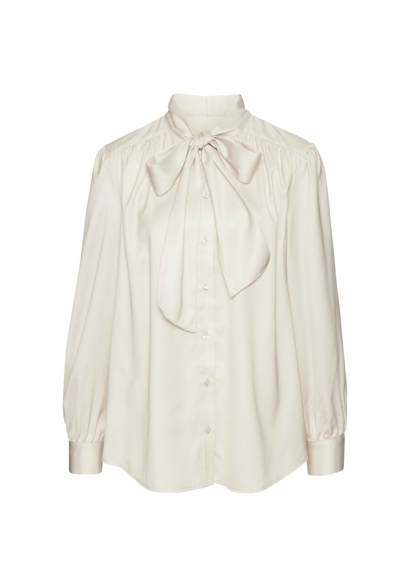 Blusa di seta color crema con un grande fiocco al colletto, chiusura con bottoni e maniche lunghe a sbuffo. Tessuto liscio con una vestibilità rilassata.