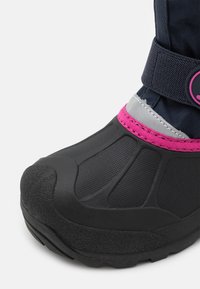 Černá voděodolná bota s texturovanou gumovou špičkou, růžovými a stříbrnými akcenty, a textilním svrškem, který je upevněn pomocí suchého zipu.