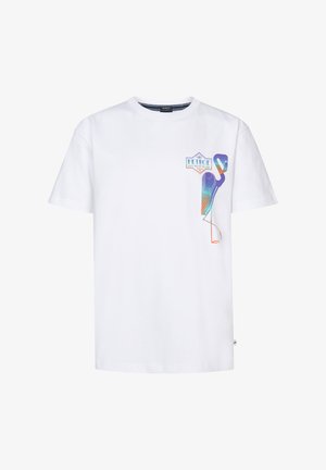 Biała bawełniana koszulka z kolorowym graficznym wzorem ptaka na klatce piersiowej; zestawiona z jasnoniebieskimi dżinsowymi szortami; białe trampki z czarnymi akcentami.