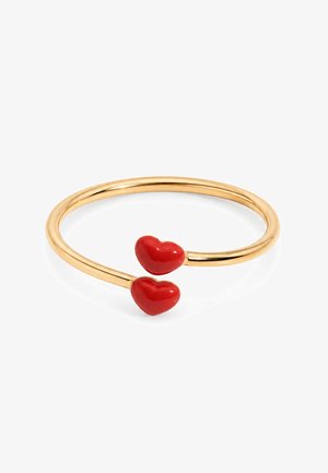 Bracelet ouvert en or avec deux extrémités en forme de cœur rouge sur fond blanc.