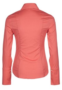 Camisa de manga larga color coral con un diseño ajustado, cuello puntiagudo y puños abotonados que cuentan con un pequeño acento dorado en el puño.