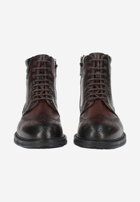 Bottes en cuir marron avec un design à lacets, des détails brogues, et un bout arrondi. Elles possèdent une semelle en caoutchouc noire et une fermeture éclair latérale.