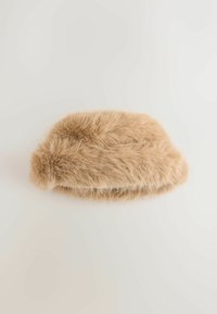 Beige faux fur headband with a soft, fluffy texture, rounded shape, and a band that curves slightly for a snug fit.