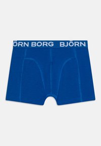 Plave bokserice od mekog materijala, s širokim elastičnim pojasom na kojem piše "BJÖRN BORG" bijelim slovima i kontrastnim šavovima.