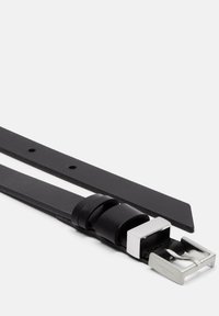 Czarny skórzany pasek z kwadratową srebrną klamrą metalową, z gładką teksturą i kilkoma otworami do regulacji wzdłuż paska.