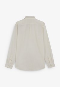 Langærmet skjorte i lyse beige, med knapkrave, rygfæld og knapmanchetter. Glat, let stofstruktur.