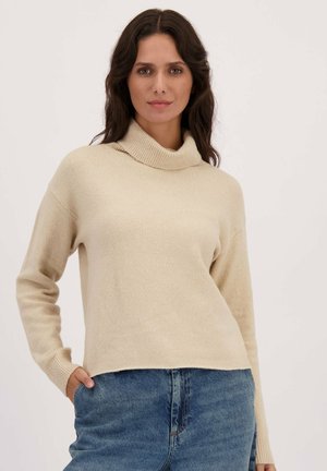 Beige trui met een col, lange mouwen en ribgebreide manchetten. Gemaakt van zacht materiaal, heeft een losse pasvorm met een cropped zoom.