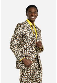 Leopardenmuster-Anzug mit gelben Akzenten, bestehend aus einem taillierten Blazer und passenden Hosen. Glatter Stoff mit kontrastierenden Mustern und Details.