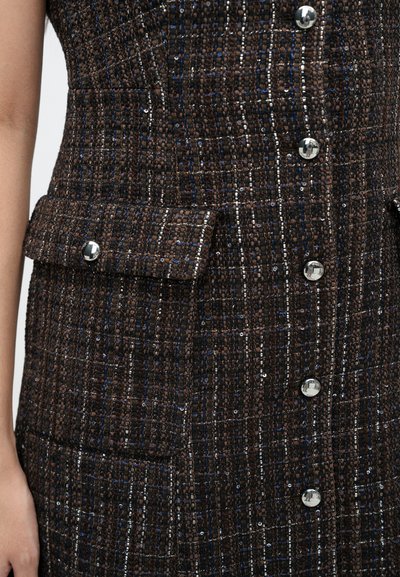 Vestido de tweed en marrón con acentos en azul y plata. Presenta un patrón texturizado, bolsillos con solapa y botones plateados brillantes en la parte delantera.