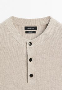 Beiges, geripptes Baumwoll-Henley-Shirt mit drei schwarzen Knöpfen und rundem Ausschnitt, mit dem Label Massimo Dutti, hergestellt in China.