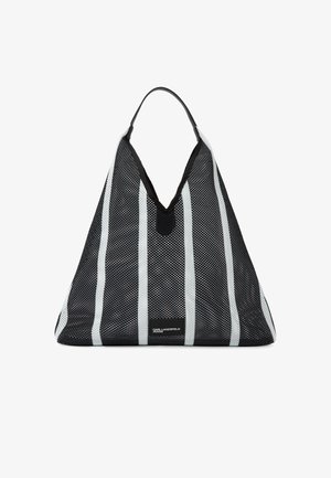 Τσάντα τοτ με μαύρες και λευκές ριγέ, σε σχήμα τριγώνου και με μια μαύρη λαβή, που φέρει μια μικρή ετικέτα Karl Lagerfeld Jeans.