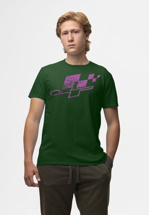 Grøn bomulds t-shirt med et struktureret lilla grafisk design på forsiden. Klassisk pasform med korte ærmer og rund halsudskæring.