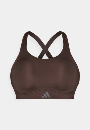 Sutien sport maro, cu o textură netedă, având un design cu bretele încrucișate la spate și un mic accent de logo. Confecționat din material elastic pentru susținere.