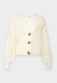 Cardigan cropped color crema con scollatura a V profonda, lavorazione a maglia texture e quattro grandi bottoni rotondi in tonalità contrastanti.