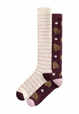 Deux chaussettes montantes, une crème avec des rayures rose clair et un bout foncé, l'autre violet foncé avec des motifs de buffle marron et des flocons de neige blancs.