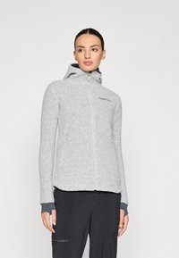 Veste en polaire gris clair avec fermeture éclair à l'avant, capuche et poches latérales. Présente des poignets contrastés et un logo sur la poitrine. Texture lisse.