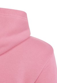 Sudadera rosa con un tejido texturizado y acanalado. Presenta un cuello alto y costuras de hombro caídas. El color es uniforme, sin patrones ni acentos.