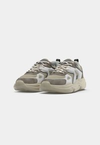 Pohodlné tenisky v béžovej a šedej farbe, so sieťovaným zvrškom a semišovými akcentmi, hrubou krémovou podrážkou a kontrastným čiernym pätovým pásikom.
