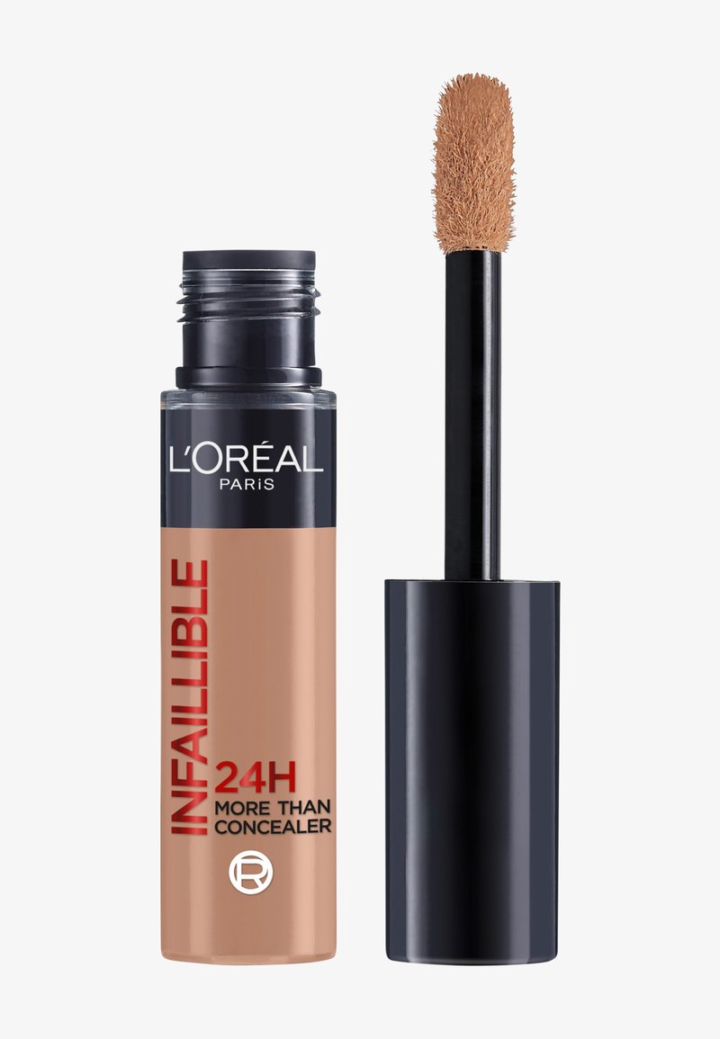 L'Oréal Paris Infallible 24H concealer met zwarte dop en applicator, beige vloeistof op sponsapplicator tegen een witte achtergrond.