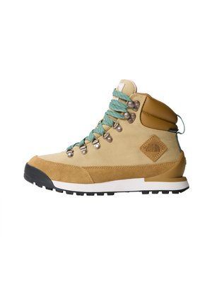 Beige Wanderschuh mit einem Obermaterial aus Wildleder und Canvas, türkisfarbenen Schnürsenkeln, gepolstertem Schaft und schwarzem Gummisohle mit strukturiertem Grip-Muster.
