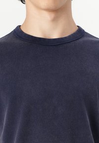 Navy blue t-shirt made of soft cotton, featuring a crew neckline and short sleeves. Smooth texture with a slightly fitted shape.