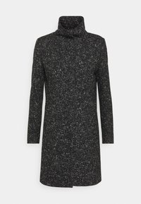 Svart och vit prickig lång kappa med hög krage och långa ärmar, i rak skärning och med textilstruktur.