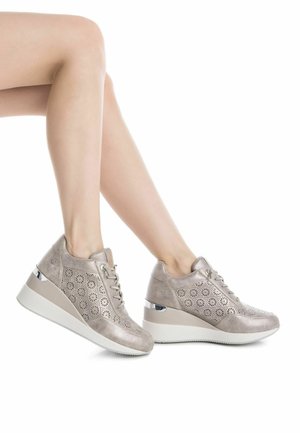Zapatillas cuña en cuero metalizado color beige con patrón floral perforado. Presenta una gruesa suela blanca y detalles metálicos en el talón.
