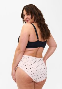 Black bra with adjustable straps, paired with high-waisted light pink panties featuring a small black heart pattern throughout.