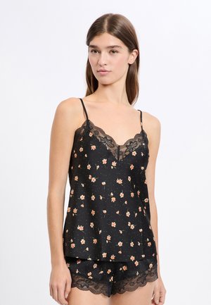 Czarny zestaw koszulki na ramiączkach z kwiatowym wzorem, wyposażony w regulowane ramiączka, koronkową lamówkę oraz zwiewny krój z jasno-różowymi kwiatami na kropkowanym tle.