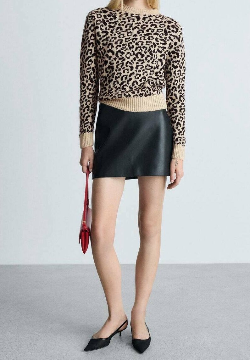 Beige pletený svetr s černými leopardími skvrnami, doplněný černou mini sukní z kůže. Červená kabelka a černé špičaté baleríny dokončují outfit.