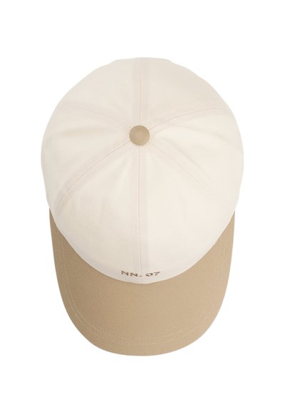 Kerman- ja beigevärinen baseball-lippalakki, jossa keskellä beige nappi ja pieni "NN.07" teksti beigen lippalakin etuosassa.