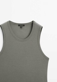 Haut en maille côtelée sans manches de couleur vert olive foncé avec encolure ronde et coutures soignées.