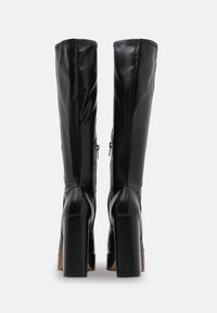 Knee-high black leather boots with a smooth finish, square high heels, and side zippers. Features stitching details along the seams.
