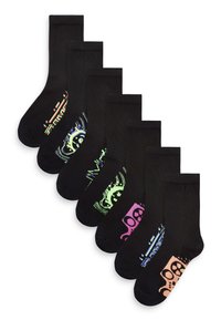 Chaussettes noires à la cheville avec divers motifs graphiques colorés, y compris des têtes de mort, des rayures et des motifs abstraits. Chaque chaussette a un accent de couleur unique.