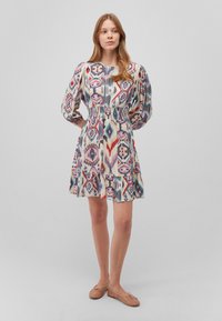 Bunt gemustertes Kleid mit langen Puffärmel, elastischem Taillenbund und gerümpftem Saum, aus leichtem Stoff gefertigt. Flache Schuhe sind inklusive.