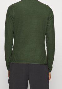 Sweatshirt verde a maniche lunghe realizzato in tessuto morbido, con scollatura arrotondata e vestibilità aderente, caratterizzato da una superficie liscia nella parte posteriore.